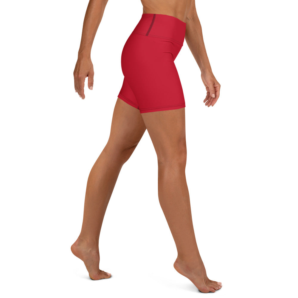A model wearing bright red high-waisted athletic shorts, shown from a side-rear angle against a plain white background.