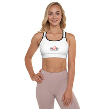 Load image into Gallery viewer, Image of front view of a fair haired model  wearing the white padded  sports bra top which has stretch and tight fit, neck and armholes contoured in black trim, bold Red Valenteen logo centre front. Teamed witha pair of neutral leggings.