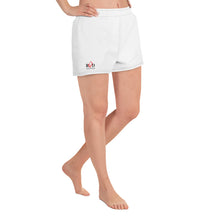 Load image into Gallery viewer, Ride side view image, of model in loose fit white running, jogging or sport shorts, which sit high on the leg, featuring elastic waist, side pockets, contrast stitching, and logo design on right side.