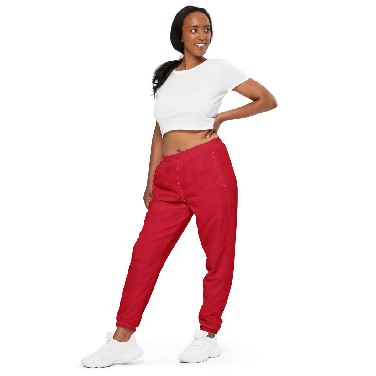 Woman wearing red pants and a white top on a white background