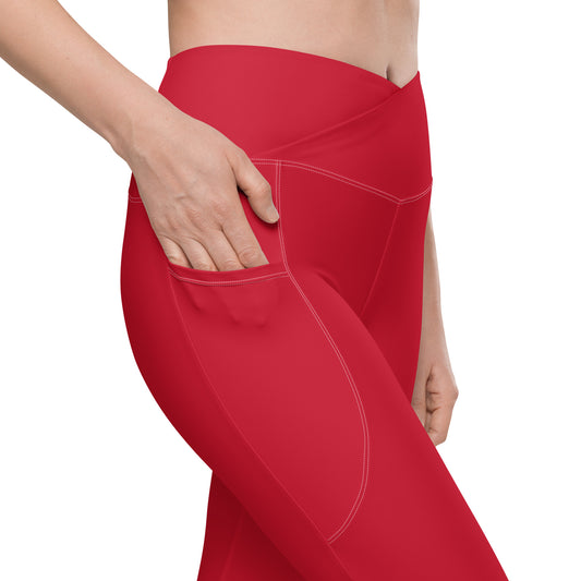 A close-up of a model wearing bright red high-waisted leggings with a side pocket, shown from the waist down against a clean white background.