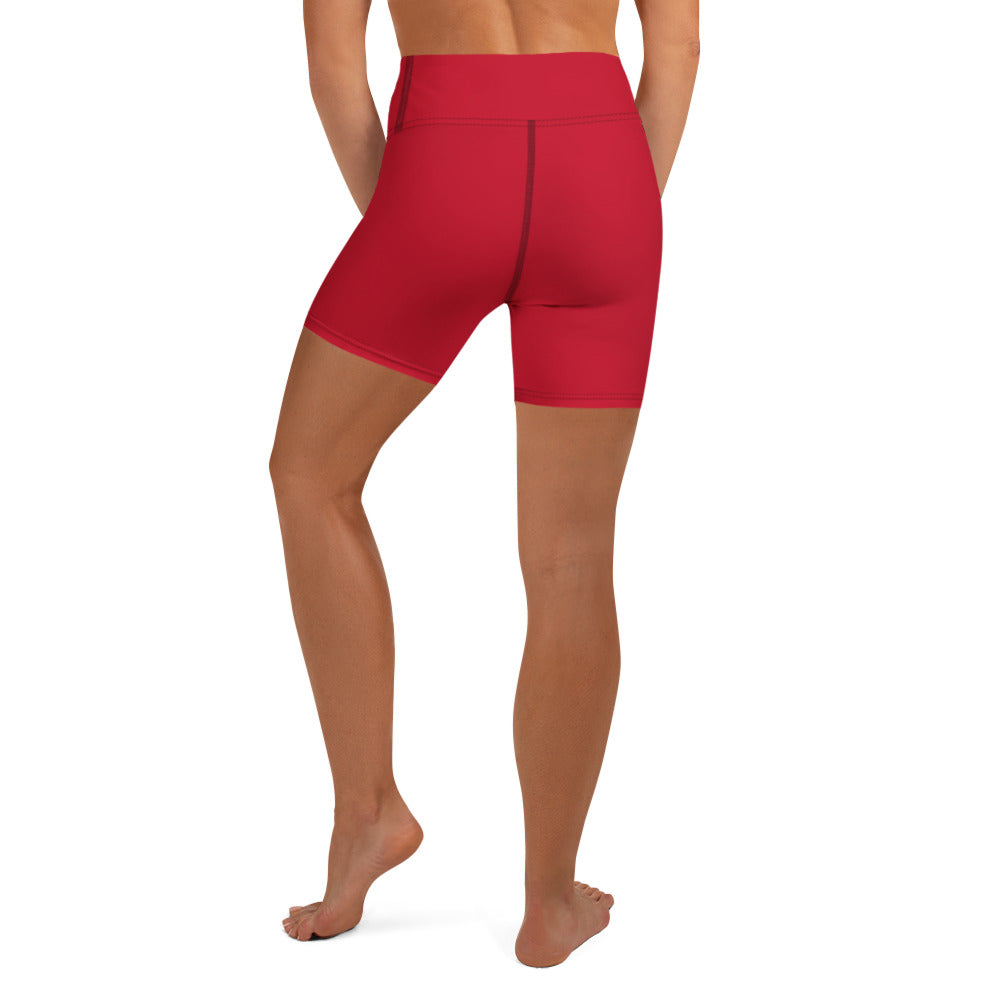 A model shown from the back wearing bright red high-waisted sports shorts, with a contrast seam stitch against a plain white background.