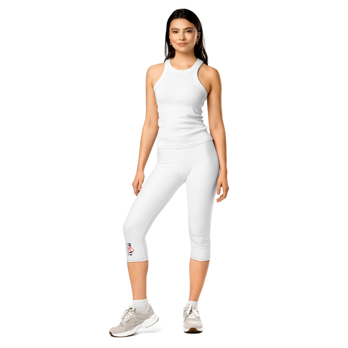 Woman wearing a white sleeveless top and capri leggings on a white background