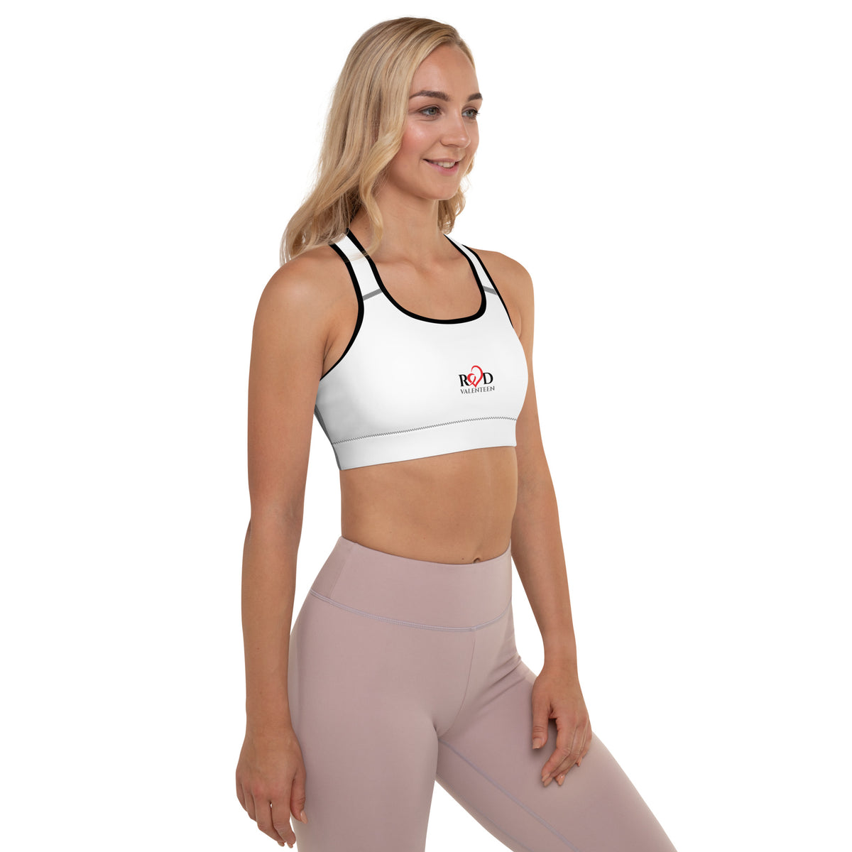 woman wearing white padded cropped Red Valenteen sports bra with beige leggings on a white background