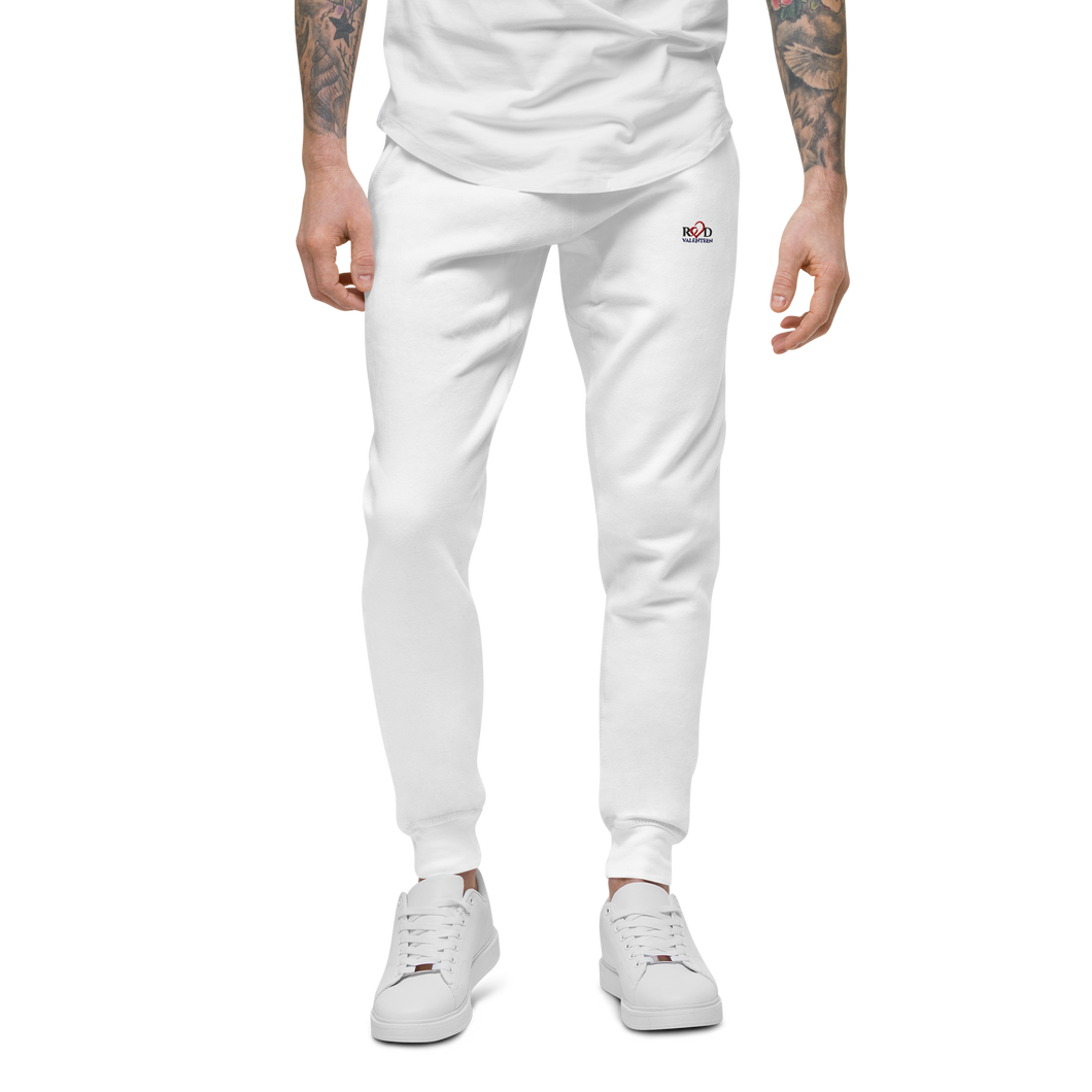 Image of a slim male model from the waist down wearing comfortable fit  luxury white cotton track pants with Red Valenteen logo on front left side at hip level, styled with a white loose tshirt and matching white sneakers 