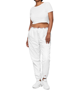 Front view image of a  woman wearing stylish, modern fit white track pants with elastic waist and elastic cuff at ankles, with subtle Red Valenteen logo around the wait and small logo on right ankle. 
